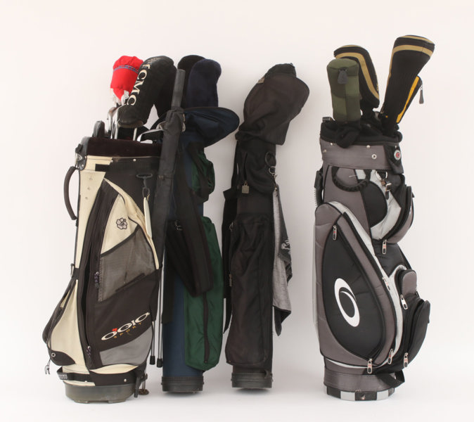 Parti golfklubbor och väskor
