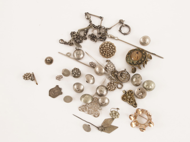 Parti knappar, dräktsmycken, m.m. mestadels i silver